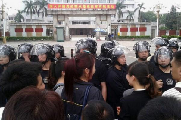 En polislinje står framför en demonstration mot en fabrik som producerar para-xylen i Maoming i Guandongprovinsen i södra Kina. (Foto: STR/AFP/Getty Images)
