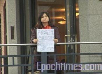 Kinesiska studenten Xiao Qiao protesterar i Stockholm, på skylten står det: ”Ge tillbaka min rättighet att återvända till mitt hemland! (Foto: Huizhi/Epoch Times)