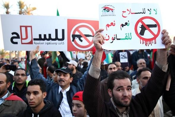 Libyska demonstranter håller en banderoll där det står på arabiska "Nej till vapen, ja till lagen. ... Det var lugnt en gång och skall vara det igen" under en protest med krav på avväpning av miliser på Tripolis Martyrs Square den 9 december 2011. (Foto: Mahmud Turkia / AFP / Getty Images)
