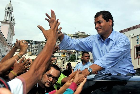 ECUADOR, Guayaquil: Ecuadoriansk  kandidat till president, Rafael Correa, (höger) hälsar sina anhängare i Guayaquil i Ecuador den 26 november 2006. Röstningen pågick på söndagen och vänsterns Rafael Correa hade försprång före den konservativa bananbaronen Alvaro. AFP PHOTO/Ricardo LANDETA