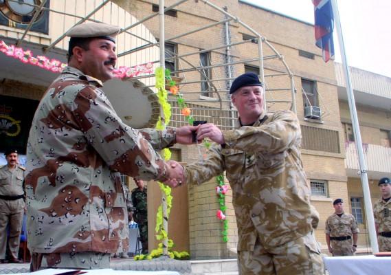 En irakisk (V) och brittisk soldat skakar hand med varandra under en ceremoni där man överlämnade en viktig bas till den irakiska armen som del av det successiva tillbakadragandet från Irak. (Foto: AFP/Essam Al-Sudani)
