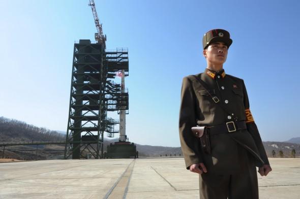 En nordkoreansk soldat står vakt framför Unha-3-raketen vid uppskjutningsplatsen Tangachai-ris rymndstation den 8 april. (Foto: Pedro Ugarte/AFP/Getty Images)