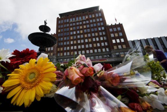 Blommor har lagts framför Arbetarpartiets huvudkontor som skadades i bombattacken i Oslo den 20 juli. (Foto: Johnathan Nackstrand/AFP/Getty Images)