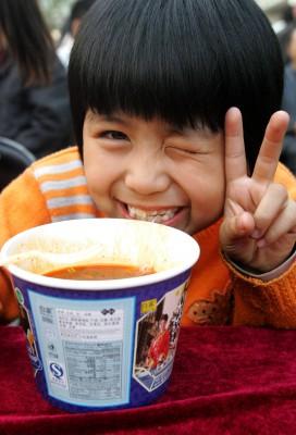 Jättegott! tycks den här glada tjejen säga när hon fick smaka på de extra långa nudlarna i staden Zhengzhou. (Foton: AFP/Getty Images)
