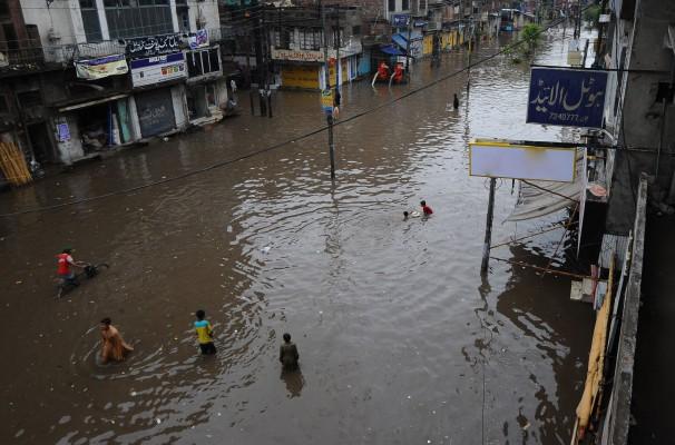 Invånare i Lahore försöker ta sig fram på gator drabbade av översvämningar den 3 juli 2011. 21 miljoner människor drabbades av översvämningar orsakade av monsunregn 2010. (Foto: AFP/Arif ALI)
