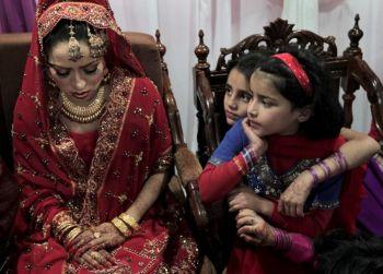 Pakistanska flickor tittar på bruden Najma Khalil under hennes bröllopsfest i Islamabad. För att mildra Pakistans elbrist meddelade premiärminister Yousuf Raza Gilani på torsdagen bland andra åtgärder, att bröllopsfester kommer att tidsbegränsas. (Foto: Behrouz Mehri / AFP / Getty Images)