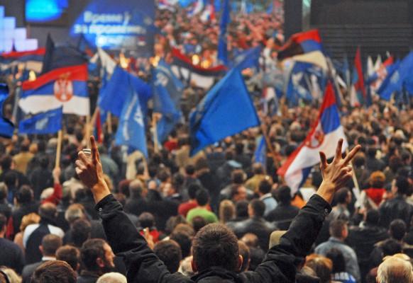 Vårvärmen hjälpte inte Serbiens reform- och EU-vänliga partier i parlamentsvalet. En stark framgång för nationalisterna bäddar nu för ytterst komplicerade regeringsförhandlingar. På bilden: en supporter till det nationalistiska partiet (SRS) håller upp de (för Serbien) typiska tre-fingrarna. (Foto: AFP/Andrej Isakovic)