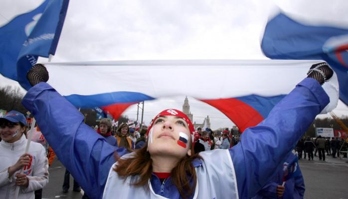 En aktivist från "Unga väktare för ett enat Ryssland" håller upp en flagga under en demonstration i Moskva på lördagen som en opposition till "Det andra Ryssland:s" marsch. (Foto: AFP/ Natalia Kolesnikova)
