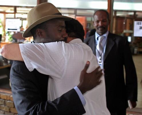 Ledaren för Sudans befrielsearmés parti Ahmed Abdelshifar Yaqub blir omkramad av en medlem i den egyptiska delegationen vid Darfurförhanlingarna i Arusha, Tanzania. (Foto: AFP/Tony Karumba)