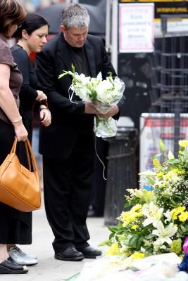 Offer i bombningar i London den sjunde juli 2005  tittar på blommorna utanför Russell Squares tunnelbanestation där muslimer bombade tre tunnelbanetåg och en buss. Blommorna lämnar ett minne av den hemska händelsen där 52 personer dog, åtskilliga skadades och fyra självmordsbombare sprängde sig själva till döds i terrordådet . Nu har de resterande tre åtalats för dåden. (Foto: AFP/WPA Pool/ Simon Dawson)