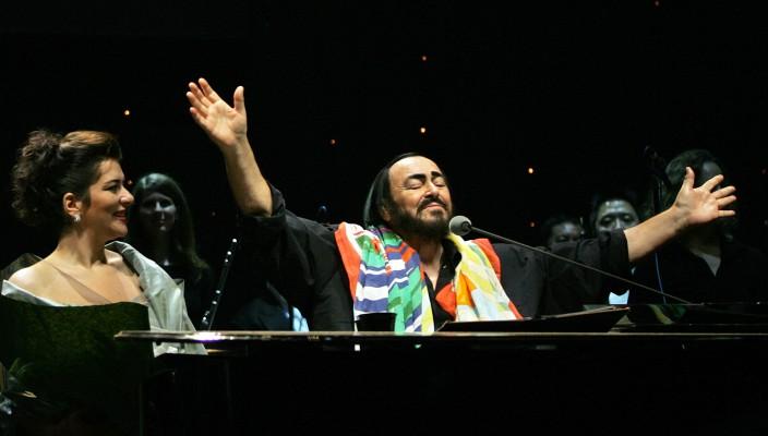 Luciano Pavarotti tar emot publikens hyllningar i Hong Kong den 2 december 2005 under sin sista världsturné, medan sopranon Annalisa Raspagliosi tittar på. (Foto: AFP/Richard A. Brooks)
