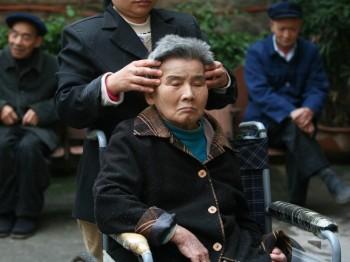 En vårdare masserar en boende på ett vårdhem för äldre, 16 oktober 2007 i Chongqing i Kina. (Foto: China Photos/Getty Images)