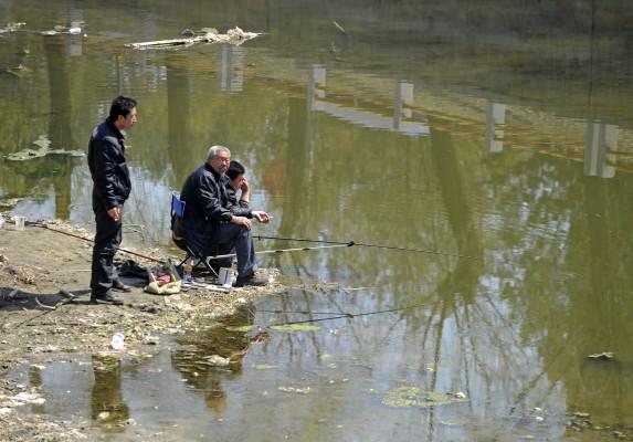 Lokalbefolkning fiskar vid en förorenad flod i Peking den 29 mars. (Foto: Liu Jin/AFP/Getty Images)
