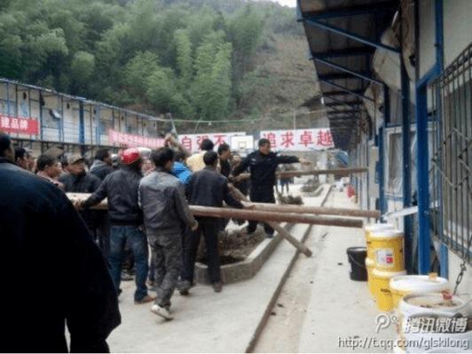 Byborna använder träpålar för att slå sönder en kontorsbyggnad tillhörande Nanshankraftverket nära Weijiangfloden i staden Guilin, Guangxiprovinsen i södra Kina, den 18 november 2013. (Foto: tieba.baidu.com)
