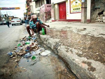 Kamp för vatten: En kvinna samlar vatten från ett trasigt rör på gatan i Haitis huvudstad Port-au-Prince den 19 januari. (Foto: Uriel Sinai / Getty Images)