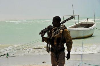 En somalisk pirat bär sitt högkalibriga vapen på en strand i centrala Somalia i staden Hobyo den 20 augusti, 2010. (Foto: Roberto Schmidt/AFP/Getty Images)