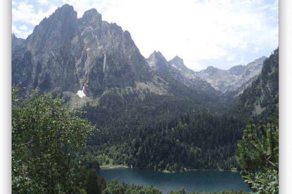 De två förtrollade, symboliska topparna i Pyrenéerna samt dammen San Mauricio. Berget Encantats i Aigüestortes nationalpark. Lleida, Spanien. (Foto: Wikimedia Commons)
