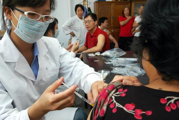 En kinesisk läkare vaccinerar mot svininfluensa. Det kinesiska hälsoministeriet har sagt att det planerar att vaccinera 65 miljoner människor före slutet av 2009. (Foto: AFP)