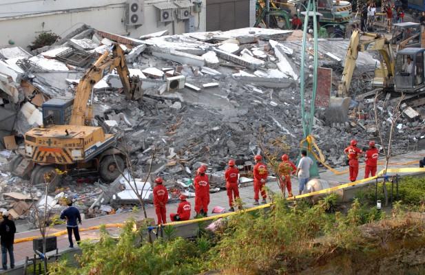 Räddningsmanskap står bredvid en möbelaffär som kollapsat i Pingtunglänet i södra Taiwan den 27 december. Ett större jordskalv skakade Taiwan dagen innan. En person dödades och minst 29 skadades.(Foto: AFP/Sam Yeh)

