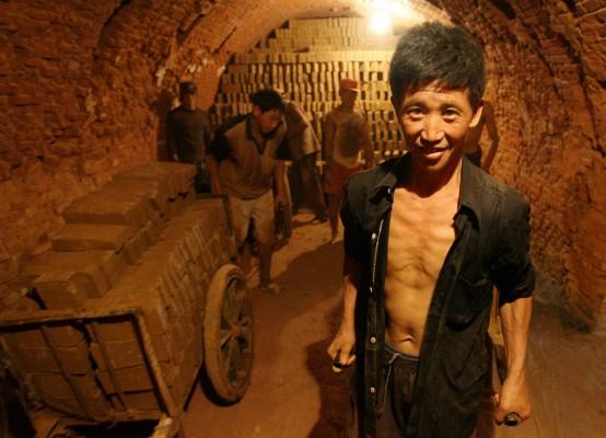 Kinesiska arbetare staplar tegelsten i en fabrik i juli 2007. Skandalen om slavarbete 2007 avslöjades när ca 400 föräldrar postade en vädjan på internet om att rädda deras barn som enligt föräldrarna hade sålts till slavarbete. (Foto: AFP/Mark Rarlston)
