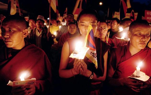 Tibetanska munkar i exil håller tända ljus under en protestmarsch den 20 november i New Delhi. (Foto: AFP/Manan Vatsyayana)
