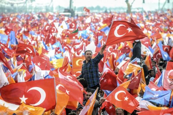 Recep Tayyip Erdogans supportrar viftar med AK-Partiets och turkiska flaggor under ett valmöte i Istanbul den 23 mars. (Foto: Bulent Kilic/AFP/Getty Images)