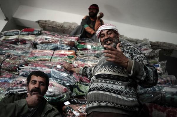 Palestinska arbetare för UNRWA (United Nations Relief and Works Agency) delar ut filtar till hemlösa i organisationens lager i Gaza, den 29 januari 2009. (AFP PHOTO/ Oliver Laban-Mattei)
