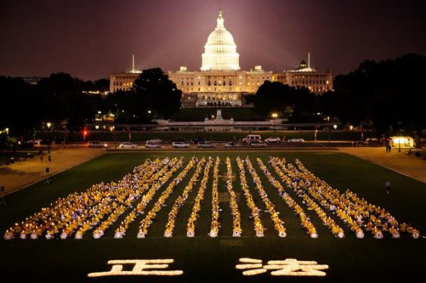 För att uppmärksamma årsdagen då förföljelsen av Falun Gong började, höll utövare en vaka med levande ljus på National Mall den 18 juli 2013 i Washington, DC.  De två upplysta kinesiska tecken "Zheng Fa" framför utövarna kan översättas med "helande av universum." (Foto: Edward Dai / Epoch Times) 