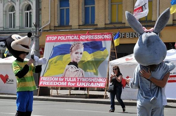 Fotbollsfans står bredvid en skylt som kräver att Ukrainas fängslade ex-premiärminister Julia Tymosjenko släpps fri. (Foto: Genya Savilov /AFP/Gettyimages)