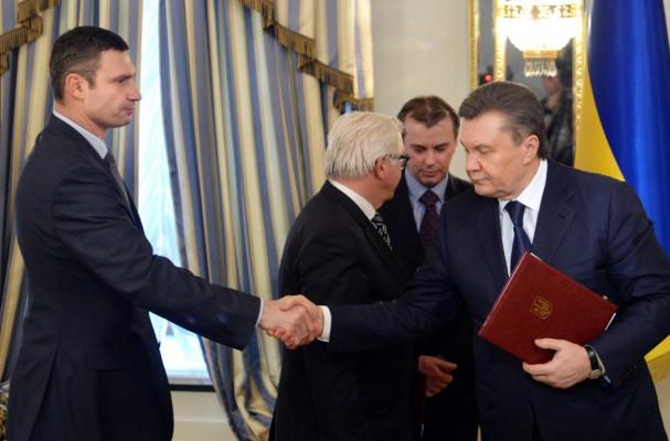 President Viktor Yanukovytj och Polens utrikesminister Radek Sikorski skakar hand efter undertecknandet av överenskommelsen om hur krisen i Ukraina ska lösas. (Foto: AFP/Sergei Supinsky)  