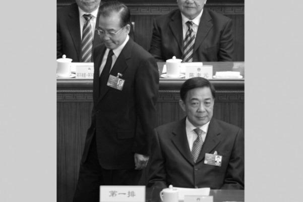 Kinas premiärminister Wen Jiabao (t.v.) går bakom Chongqings partiledare Bo Xilai under öppningssessionen av den Nationella folkkongressen i Folkets stora sal i Peking den 5 mars 2012. Den 14 mars gjorde Wen en del yttranden vid en presskonferens, som uppfattades som ett angrepp på Bo Xilai, och den 15 mars avskedades Bo från sin partipost. (Foto: Liu Jin/AFP/Getty Images)