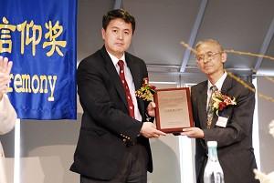 Erping Zhang (vänster) tar emot belöningen “2007 Special Spiritual Faith” från Zhong Weiguang från Chinese Cultural Freedom Movement. (Dai Bing/The Epoch Times)