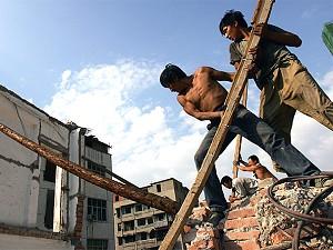 Arbetare plockar bort virke från en riven byggnad i Wuhan, Hubeiprovinsen. (China Photos/Getty Images)