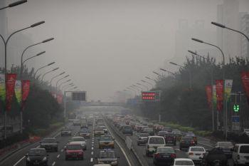 Bilar kör genom tjock smog på en gata i Peking den 21 september 2008. (Foto: Peter Parks/AFP/Getty Images)