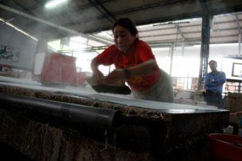 Pan Suchen vid Kuanghsings pappersfabrik i Puli, Taiwan, torkar ett pappersark. (Foto: Matthew Robertson / The Epoch Times)
