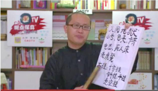 TV-personligheten Cao Baoyin höll upp en tavla med namnen på tortyrmetoder som används i arbetslägret Masanjia. Han skulle ha gjort ett kort webbprogram om ett ekonomiskt forum, men gav i stället ett känslosamt tal om den senaste tidens tortyrrapporter.  (Skärmdump av Epoch Times)