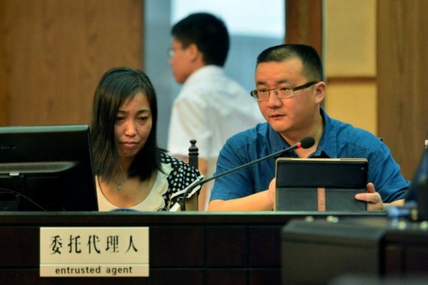 Tang Hui (t.v.), mor till ett våldtäktsoffer, sitter bredvid sin advokat i Folkets provinsdomstol i staden Changsha i Hunanprovinsen den 15 juli 2013. Domstolen tilldelade Tang skadestånd efter att hon skickats till ett arbetsläger för att ha krävt att de som angripit hennes dotter skulle straffas. (Foto: STR/AFP Getty Images)