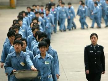 Fångar och en poliseskort under en öppen dag i ett fängelse i Nanjing, 2005. Nyligen har krav väckts på att ta bort det nuvarande systemet med arbetsläger i Kina. (Foto: STR/AFP/Getty Images)