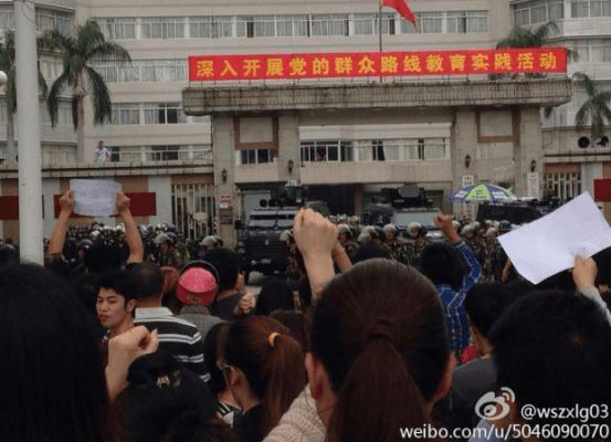 Invånare protesterar mot en PX-fabrik och polisens våldsamma aktion, framför en kraftigt bevakad regeringsbyggnad i Maoming, i Guangdongprovinsen den 3 april. (Foto: Weibo)
