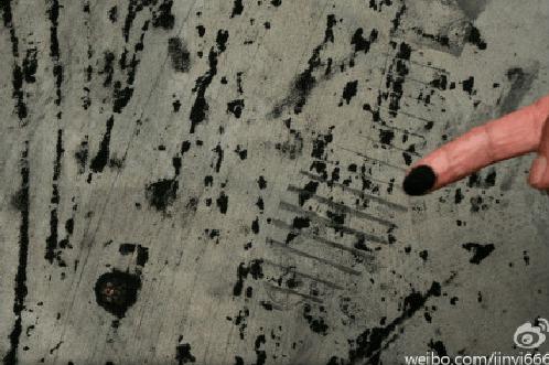 Ett finger pekar på koldamm som har regnat in i ett hem. (Weibo.com)
