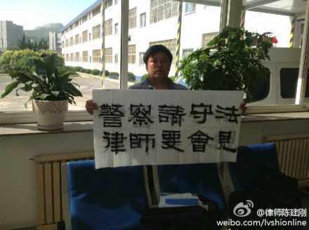 Kinesiske advokaten Chen Jiangang håller upp ett plakat där han ber polisen i Dalian att träffa honom och andra advokater som försvarar 13 Falun Gong-utövare i Dalian. (Weibo.com) 