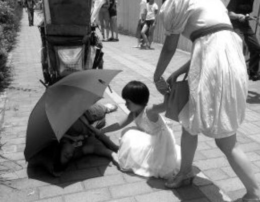 En liten flicka håller upp ett parasoll för en gatsopare som har kollapsat i värmen. Lurad! (Skärmdump/Secret China)