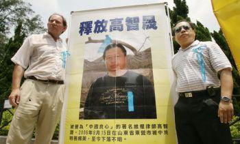 Europaparlamentets vice ordförande Edward McMillan-Scott (t.v.) tillsammans med Albert Ho, demokratilagstiftare i Hongkong, vid ett porträtt av den försvunne människorättsadvokaten Gao Zhisheng från Kina, augusti 2006. (Mike Clarke/AFP/Getty Images)