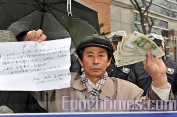 Qihao Jin visar upp de 500 dollar som kinesiska myndigheter gav honom för att bli hemlig agent. (Foto: Zheng Renquan/ The Epoch Times)