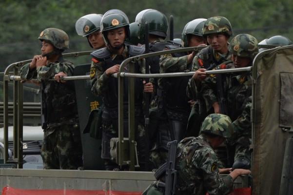 Kinesisk paramilitär polis förbereder sig för att åka lastbil under en "styrkedemonstration" i Urumqi den 29 juni 2013. Den kinesiska regimen reviderar lagar för att förhindra militära informationsläckor. (Foto: Mark Ralston / AFP /Getty Images)