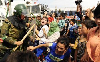 Kinesisk kravallpollis gör sig redo att slå ner uiguriska kvinnor som protesterar i Urumqi, Xinjiangprovinsen i östra Kina den 7 juli 2009. (Foto: Peter Parks/ AFP/ Getty Images) 