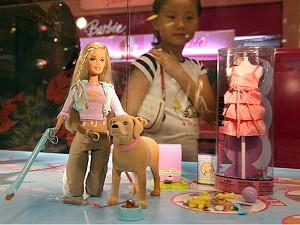 En kinesisk flicka tittar på en Barbiedocka, tillverkad av den amerikanska leksaksgiganten Mattel, som fortfarande säljs i Kina trots att den återkallats i USA. (Foto: Mark Ralston/AFP/Getty Images)