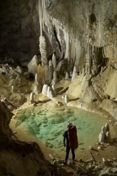 En forskare i grottan ” Pearlsian Gulf” med formationer av kalkspat i bakgrunden. (Max Wisshak/speleo-foto.de)