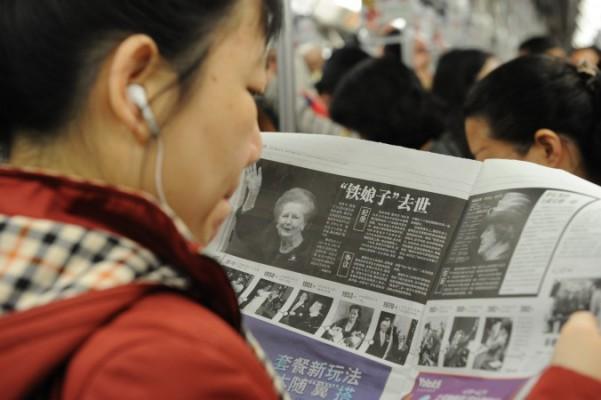 En kinesisk kvinna läser om  Margaret Thatchers död, den 9 april 2013. Kommunistpartiet har nu förbjudit inhemska medier att använda utländska medierapporter. (Foto: Peter Parks/AFP/Getty Images)