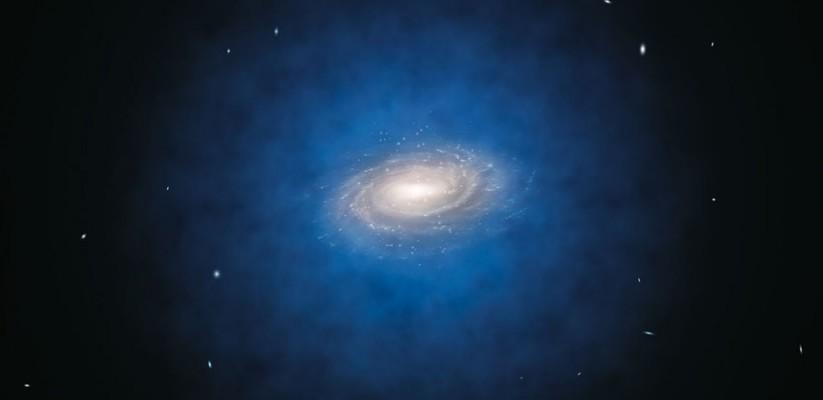 En konstnärs bild av Vintergatan. Den blåa halon av materia som omger galaxen indikerar den förväntade fördelningen av den mystiska mörka materian. (L. Calçada/ESO)